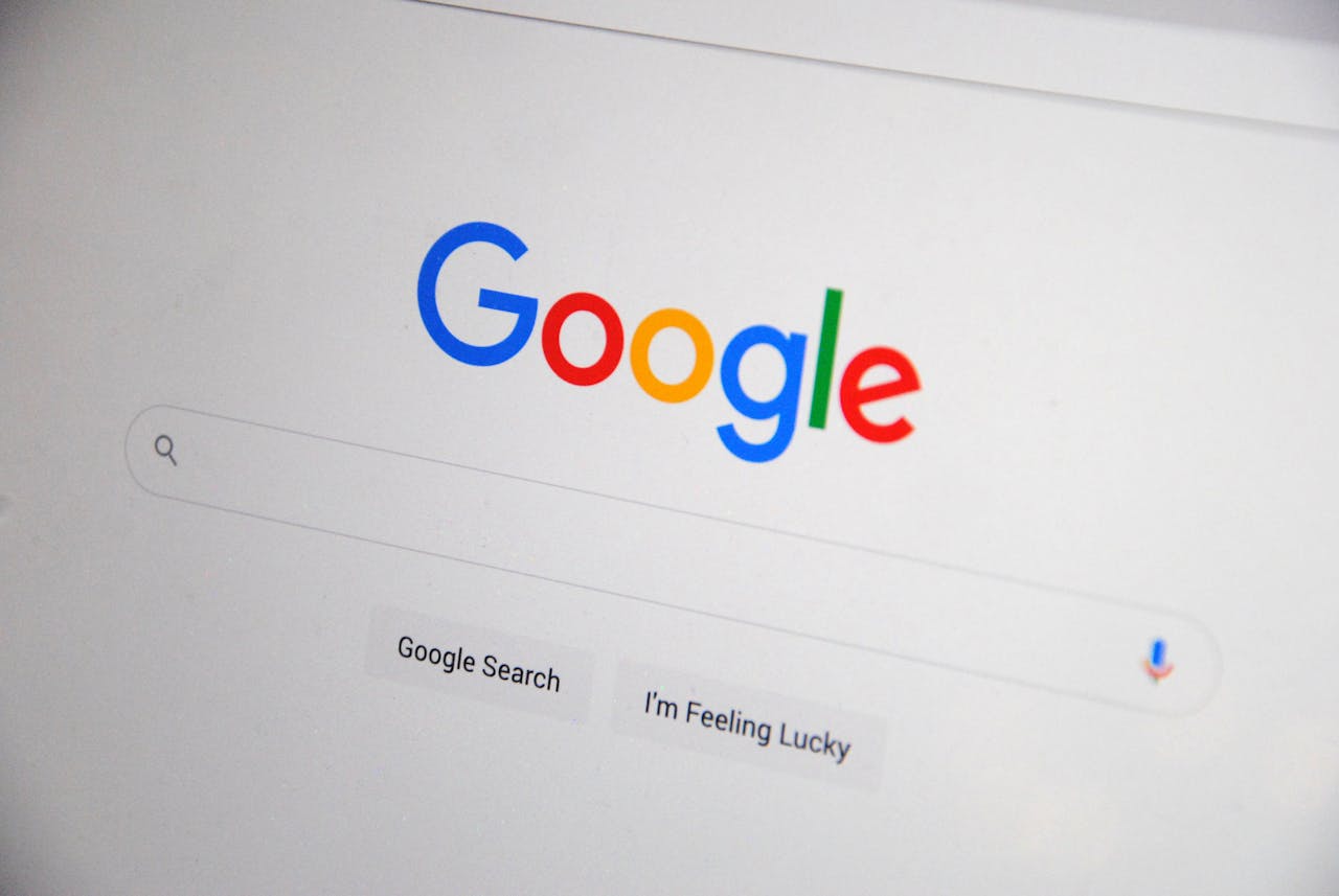 hero-img Close-up of the Google homepage on a screen showing search options.